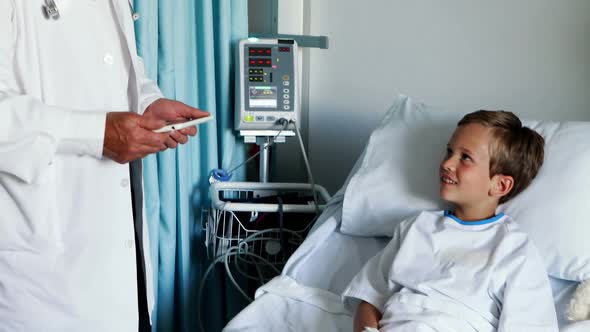 Male doctor using digital tablet during visit in ward