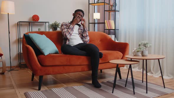 Portrait of Tired Sleepy Man Talking on Mobile Phone with Friend Making Online Conversation Home