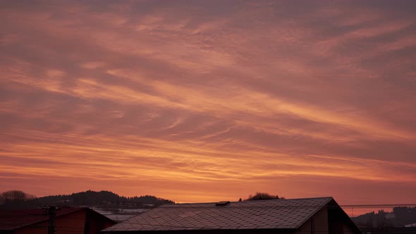 Timelapse of Moving Clouds at Sunrise Over the Roofs of Houses