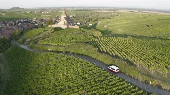 Aerial view of a campervan driving near the little village.