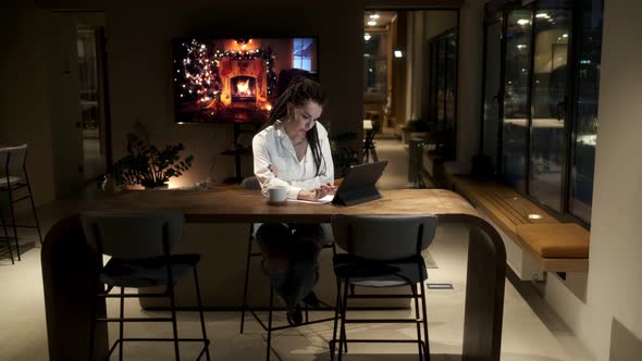 A girl with dreadlocks in a white shirt using a digital tablet,online lesson.