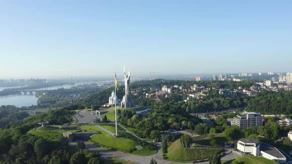 Aerial View of the Ukrainian Flag Waving in the Wind Against the City of Kyiv