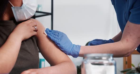 Closeup Nurse in Blue Scrubs Medical Gloves Gives Vaccine Injection Shot with Hypodermic Needle to