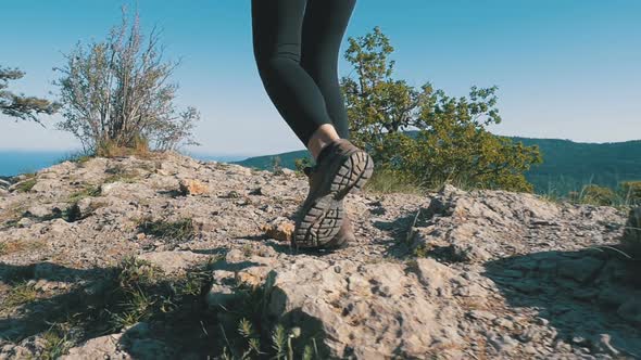 View on Feet of Traveler Woman Hiking Walking on the Top of Cliff in Mountain. Slow Motion