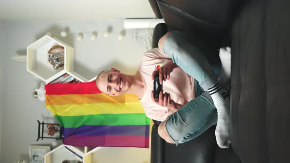 Vertical Shot of Content and Grinning Queer Nonbinary Gamer Playing with Gamepad and Enjoying Free