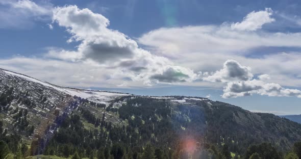 Time Lapse of Cloudscape Behind of the Mountains Top. Snow, Rocks, Cliffs and Deep Blue Sky