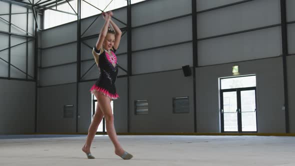 Teenage female gymnast performing at sports hall