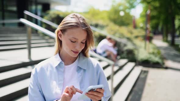 Happy Pretty Girl University Student Using Mobile Cell Phone Standing Outside