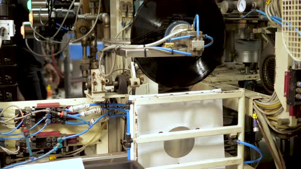 Industrial placing of vinyl record in sleeve in a record factory