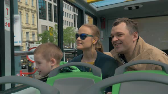 Family with child traveling around Vienna by double-decker bus