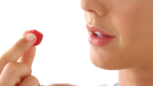 Close-up of woman having raspberries