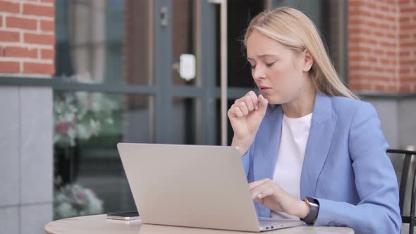 Businesswoman Coughing while Working on Laptop Outdoor