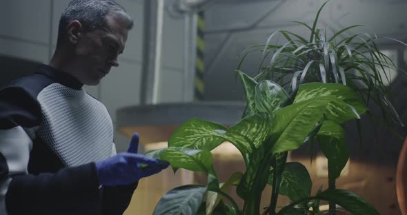 Scientist Examining Potted Plant in Mars Base alt