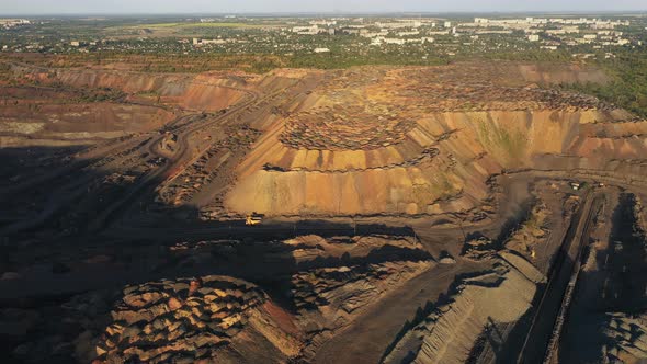 Large Mining Dump Truck Driving on a Dusty Road at the Evening