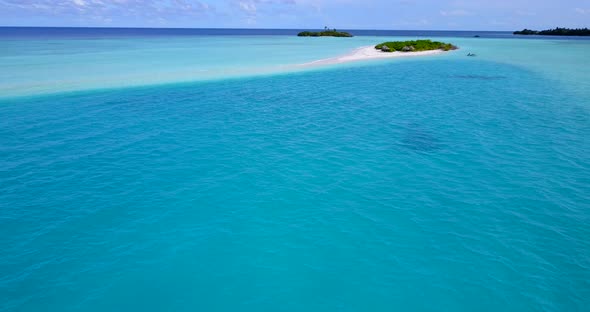Tranquil azure water in the middle of turquoise lagoon close to tiny tropical islands with lush vege