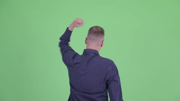 Rear View of Happy Businessman with Fists Raised