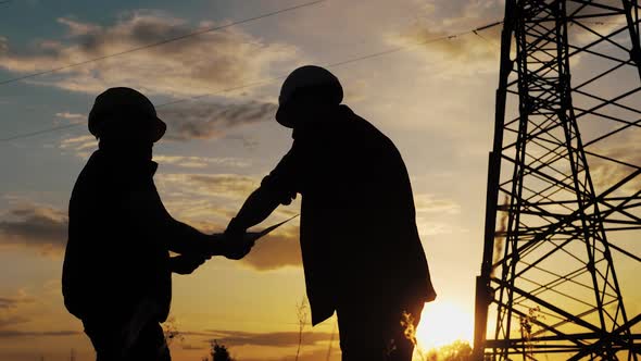 Silhouette of Engineers Looks at the Construction of High-voltage Power alt