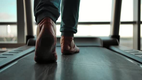 Back View of the Man in Sneakers Walking on a Treadmill