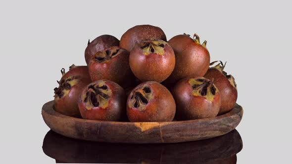 Whole ripe of organic Common Medlar rotate on white Background.