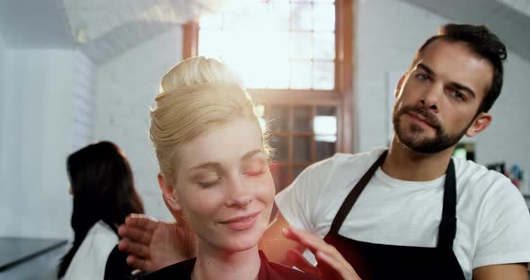 Male hairdresser styling a womans hair