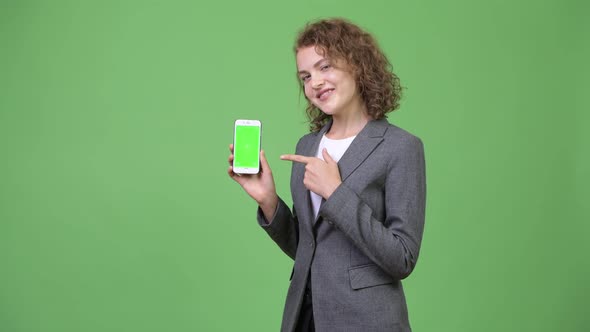 Young Happy Beautiful Businesswoman Showing Phone and Giving Thumbs Up