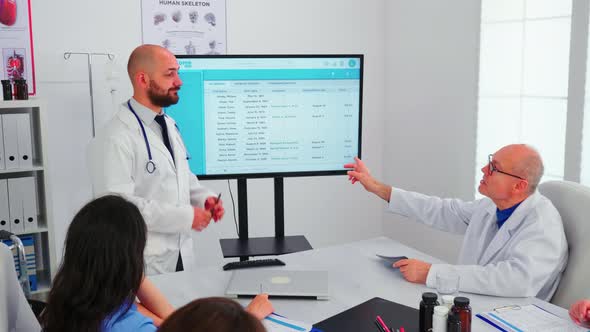 Expert Doctor Presenting to His Team the List of Sick Patients