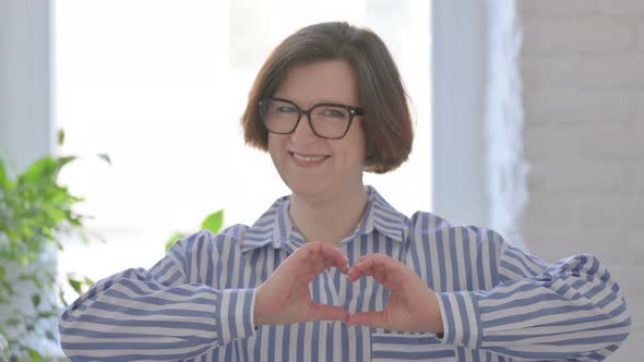 Loving Senior Woman Showing Heart Shape By Hands