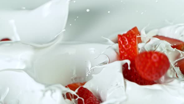Super Slow Motion Shot of Fresh Strawberries Falling Into Cream at 1000Fps