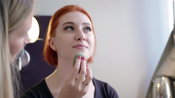 Attractive Redhaired Woman is Doing Makeup