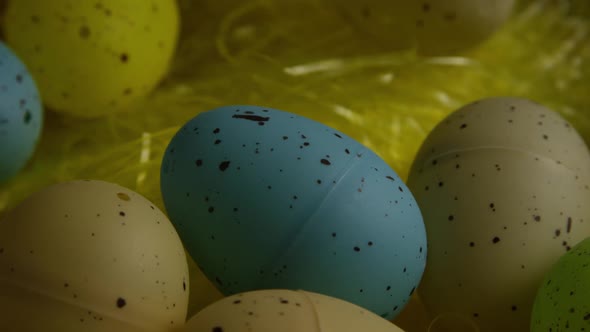 Rotating shot of Easter decorations and candy in colorful Easter grass 