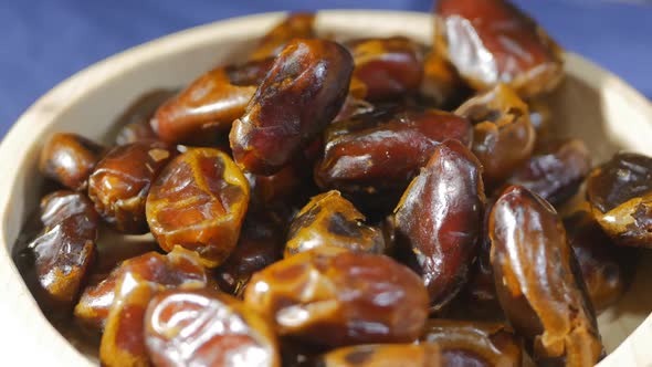 Closeup DOF Circular Rotation Sweet Dried Dates in a Wooden Bowl