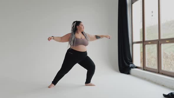 Happy Body Positive Fat Woman with Dreadlocks Doing Yoga in the Gym