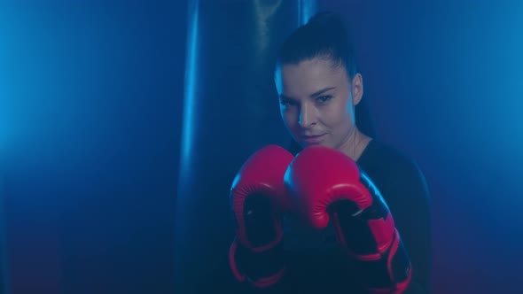 Strong girl boxer in the ring is ready to fight and calls her opponent to start
