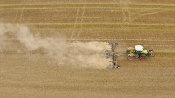  Tractor plows ground on cultivated farm field. 