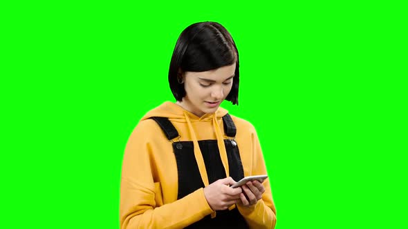Girl Looks Into the Phone and Sees Strange Photos. Green Screen