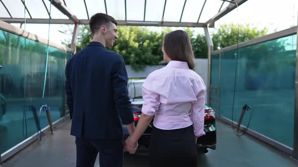 Happy Caucasian Couple Admiring Clean Vehicle at Car Wash Service Holding Hands
