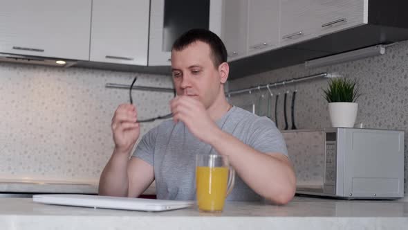 Freelancer Man Starts Work at a Laptop While Sitting at a Table at Home