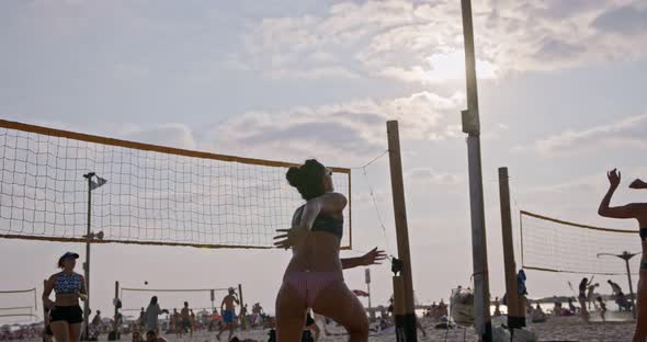 Slow motion of women playing beach volleyball during sunset