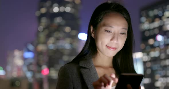 Woman use of smart phone at outdoor in the evening