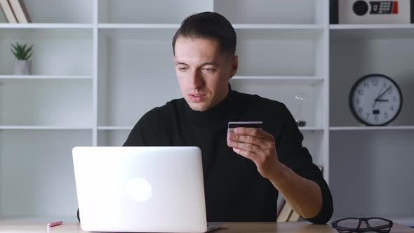 Portrait of Business Man Holding Credit Card and Using Laptop While Paying for Order in Web Store