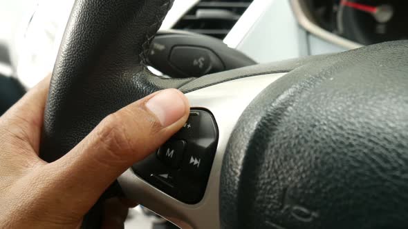 Male Hand on the Car Wheel and Volume Control