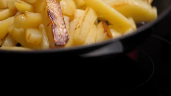 Cooking Fried Potato on Frying Pan. Roasting Sliced Potatoes