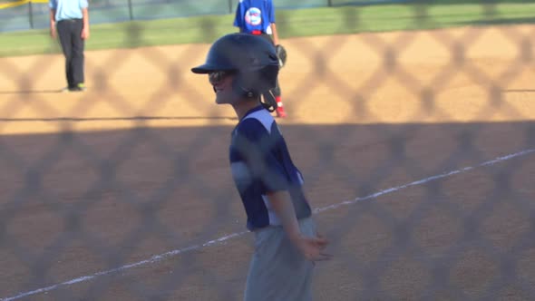 Boys celebrate a home run at a little league baseball game.