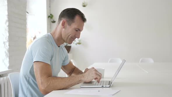 Man Typing On Laptop in Office