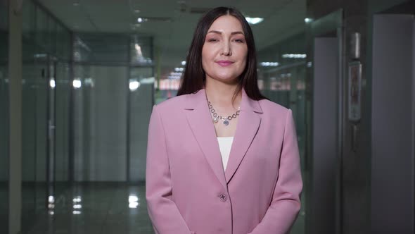 Brunette Businesswoman in Purple Jacket Poses in Corridor