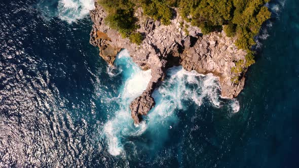 Aerial riser reveals jagged islet in picturesque Crystal Bay, Nusa Penida