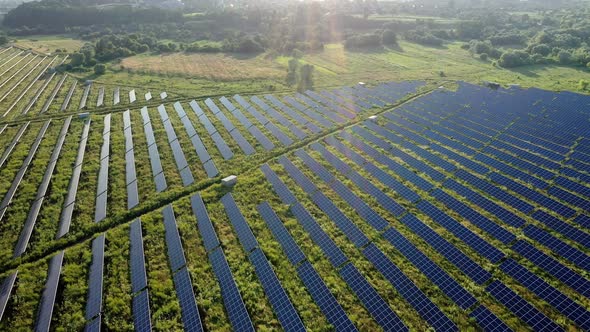 Top view of a massive photovoltaic power station located in a field at sunset