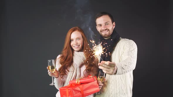 Happy Couple Celebrating New Year's with Champagne Glasses and Sparklers