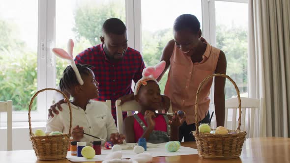 African american family painting easter eggs together at home