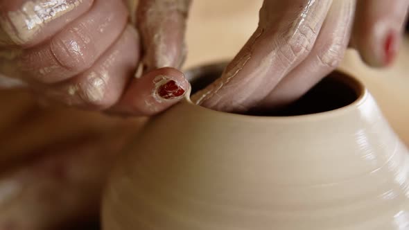 Skilled Wet Female Hands of Potter Shaping the Clay on Potter Wheel and Sculpting Vase Using Fingers